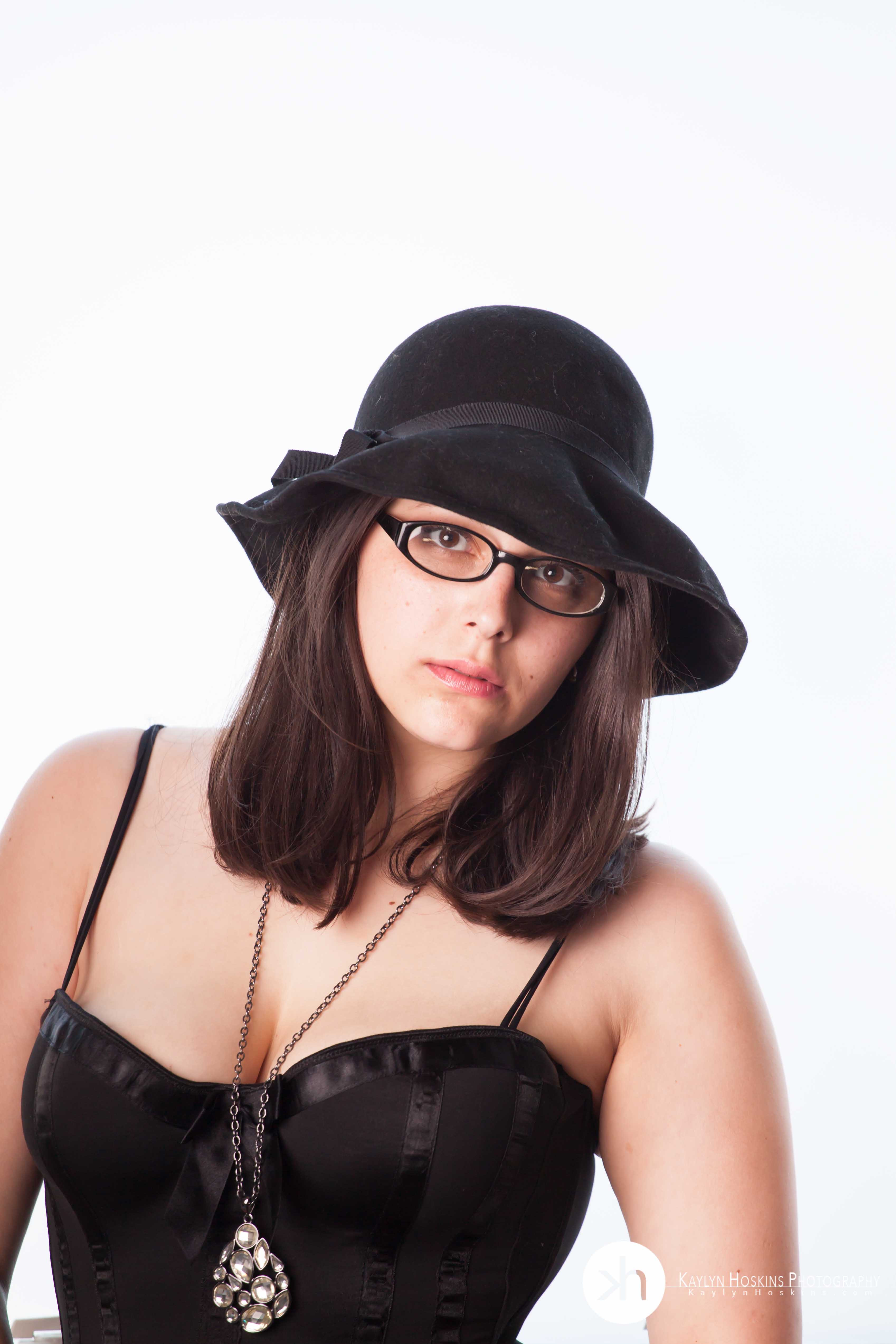 Suzie wears vintage black hat during boudoir experience in Solon, Iowa