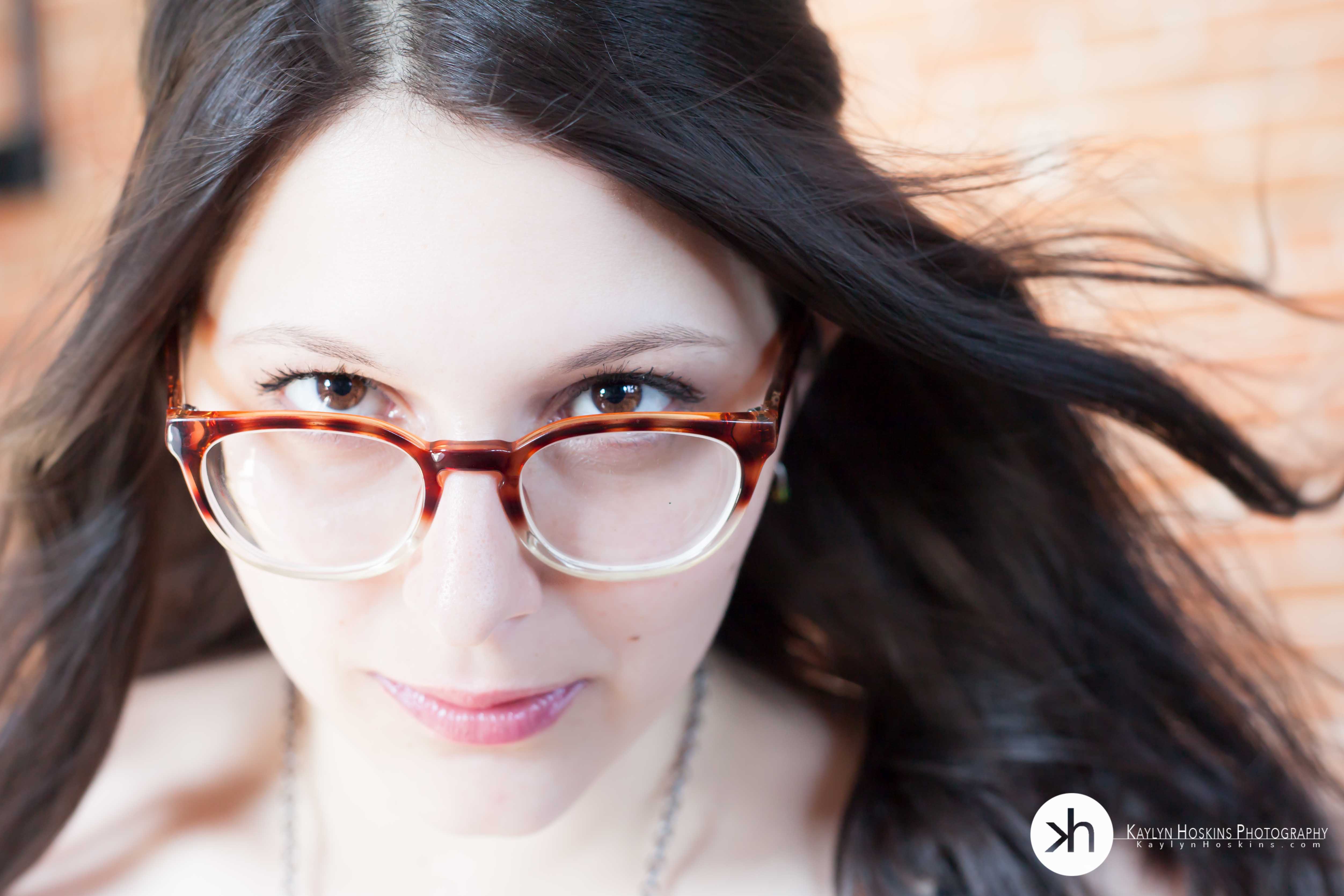 Boudoir client Suzie looks over her glasses during boudoir experience with Kaylyn Hoskins Photography