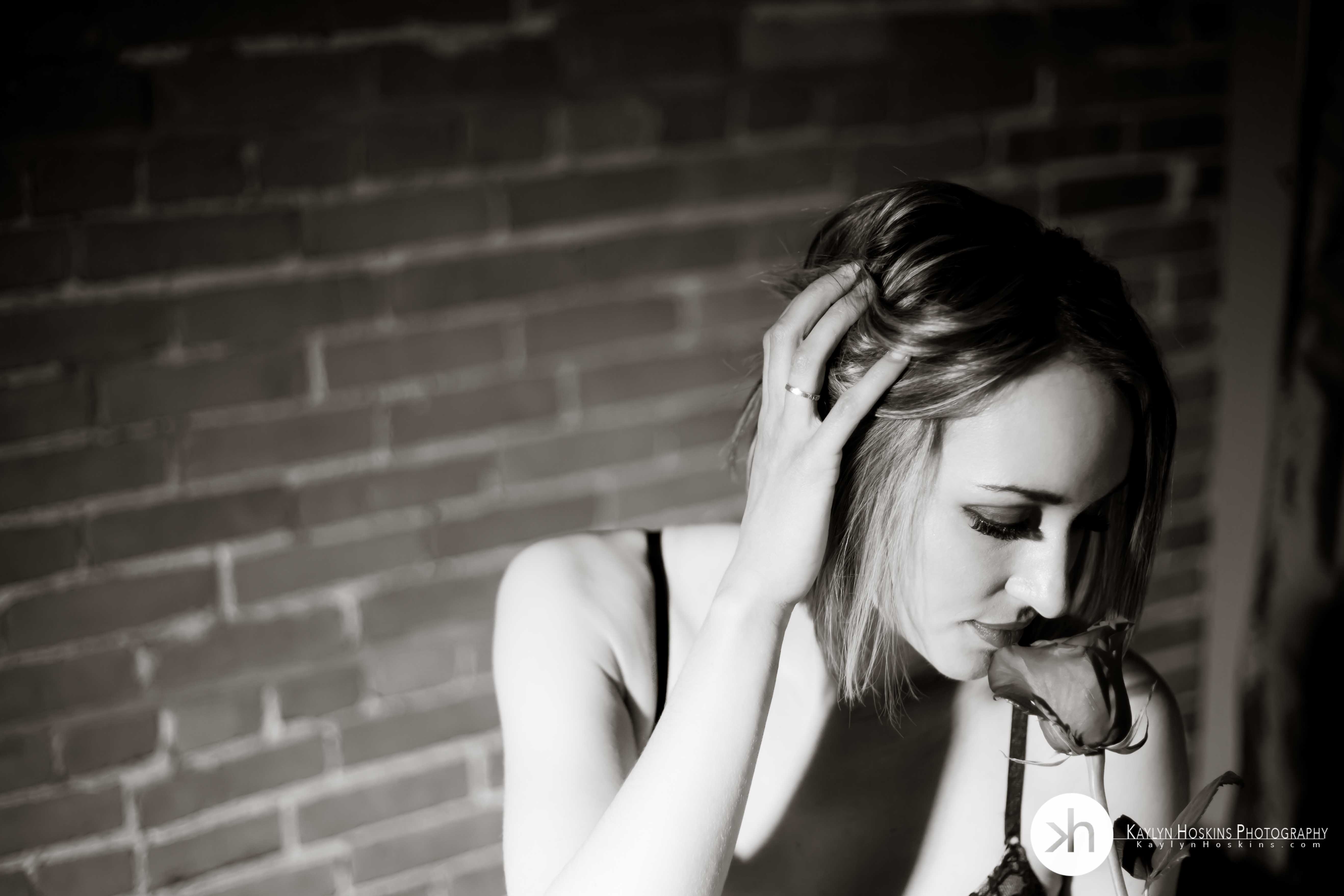 Beautiful woman in lingerie smelling red rose during Valentine's boudoir shoot