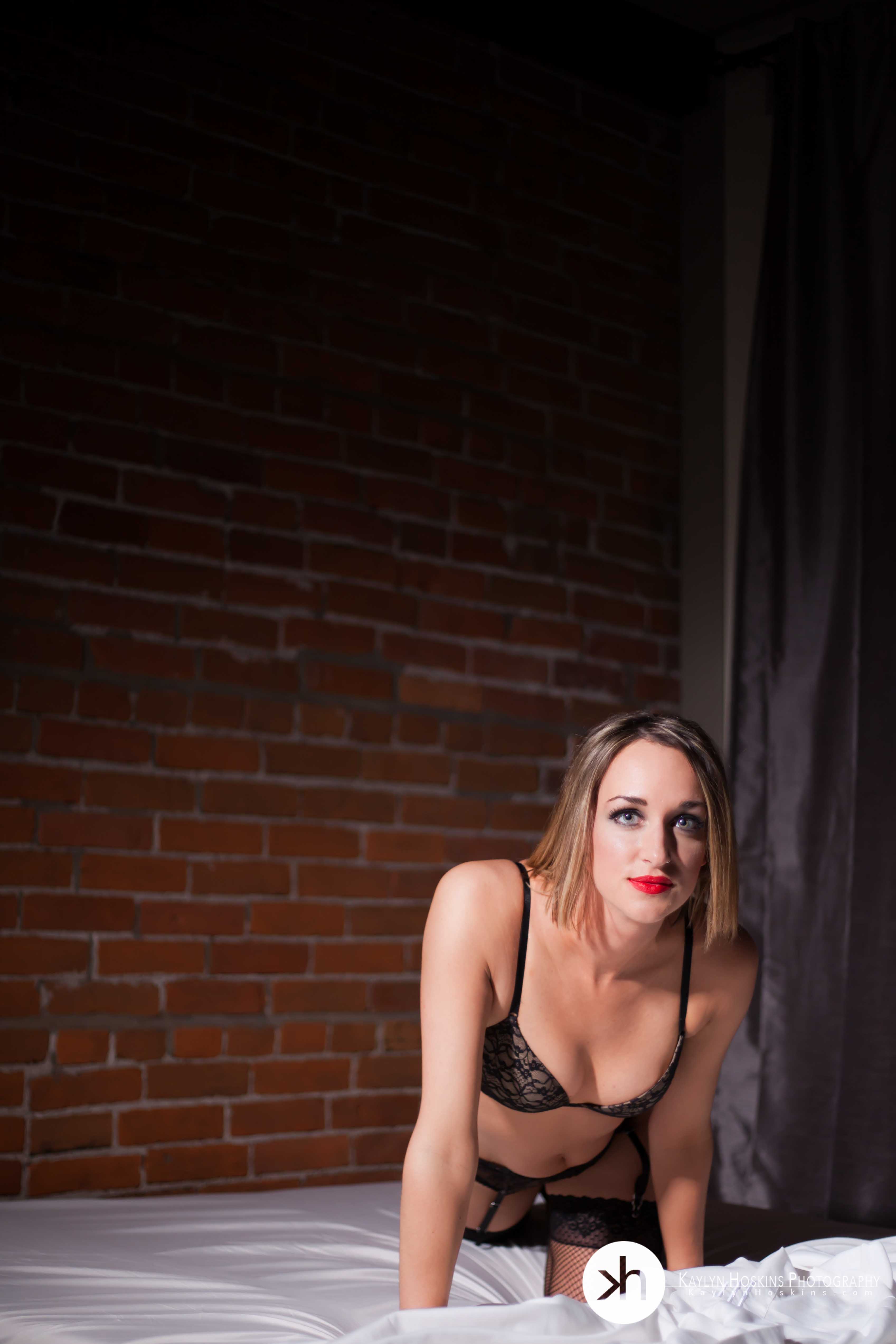 Valentine's boudoir client on bed in red lipstick & lingerie during boudoir session