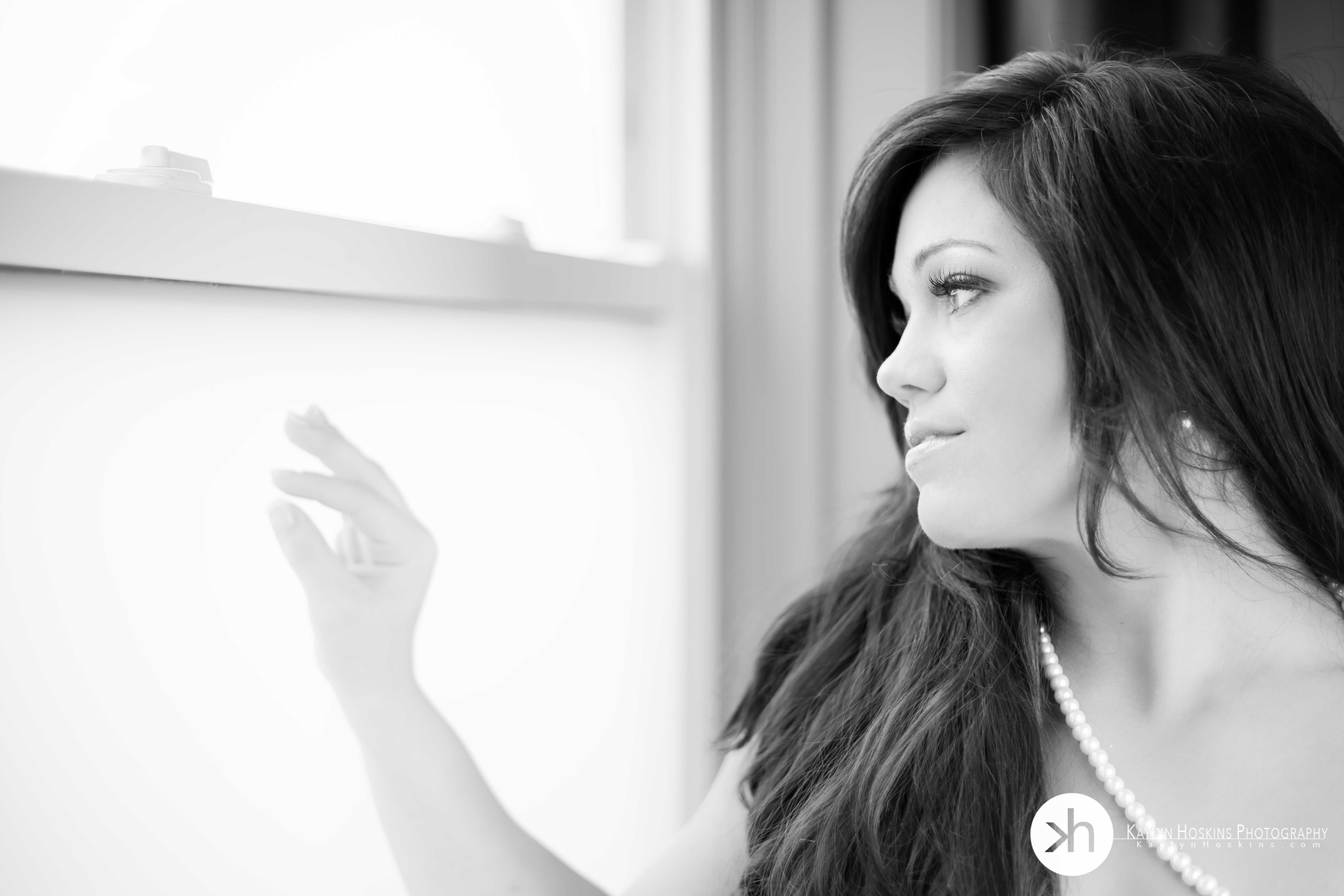 Gorgeous bride to be looking out window during boudoir experience