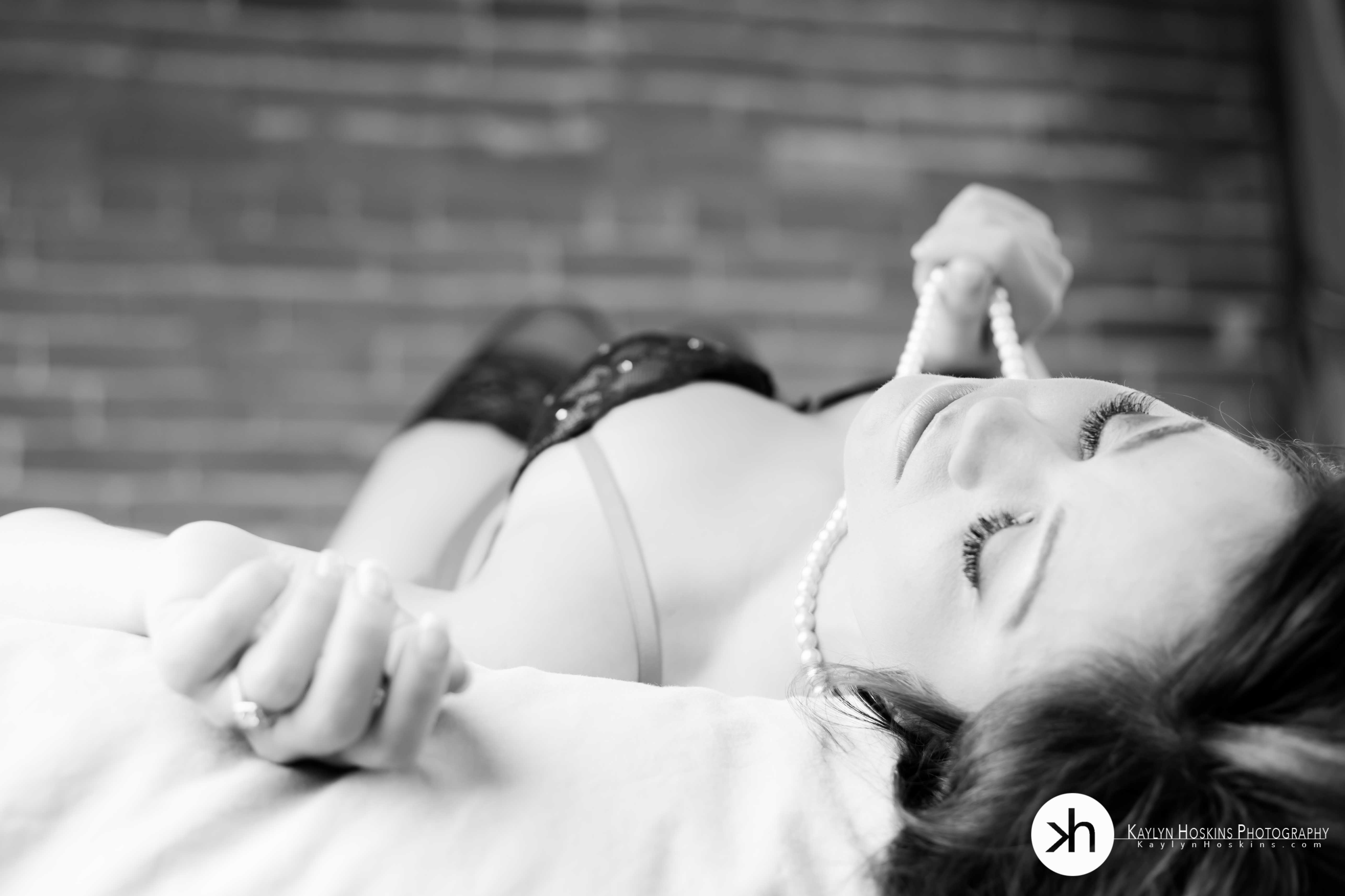 Bride to be laying in lingerie on bed during her bridal boudoir experience