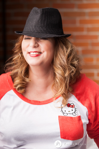 Curvy Boudoir Goddess giggles while wearing Hello Kitty tshirt while rocking sexy hat during boudoir experience 