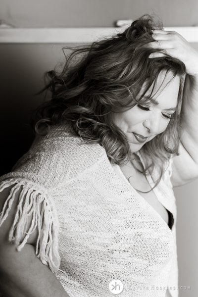 Curvy Boudoir Goddess wearing hippie cover looking down playfully during boudoir photo shoot