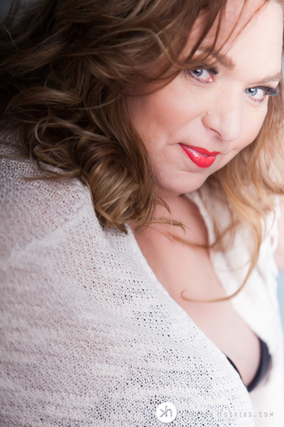 Curvy Boudoir Goddess wearing boho sweater over black bra with red lipstick during boudoir experience