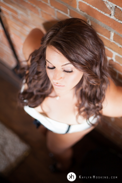 Boudoir Goddess leans up against brick wall during boudoir experience at Kaylyn Hoskins Photography