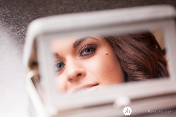 Makeup Artist looks into mirror during boudoir experience