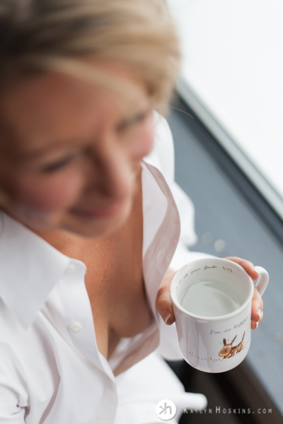 Boudoir Goddess wears husband's white shirt while holding coffee cup he gave her when they met