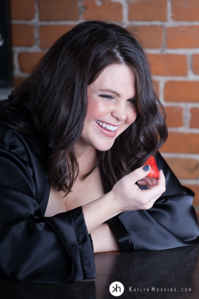 Boudoir Goddess giggles during photo shoot while sexily eating strawberry