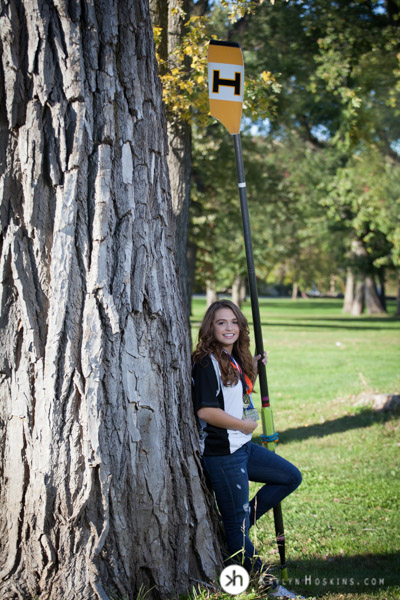 Solon Senior & Junior Rower Aurora leaning on tree at the P. Sue Beckwith, M.D. Boathouse in Iowa City