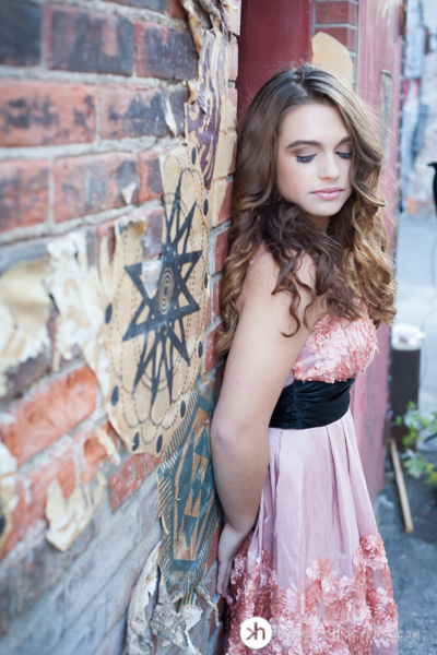 Gorgeous Solon Senior Aurora leans against artistic brick wall in alley downtown iowa city during senior pics