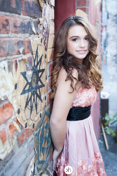 Gorgeous Solon Senior Aurora leans against artistic brick wall in alley downtown iowa city during senior pics