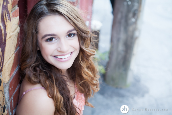 Gorgeous Senior Aurora smiles at the camera in beautiful dress during senior photos downtown iowa city