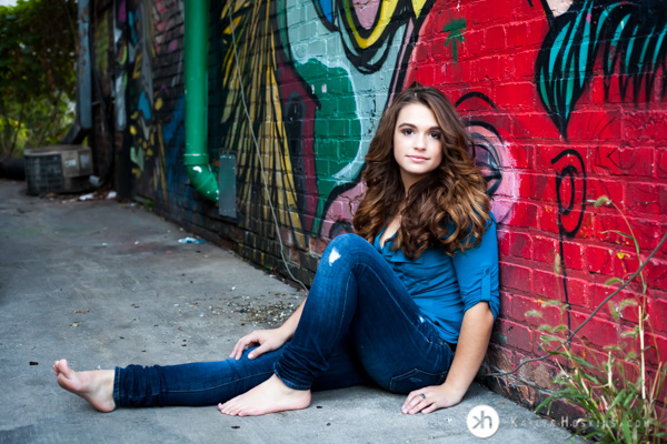 Solon Senior leans up against graffiti wall downtown iowa city during senior pictures 