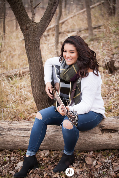 Prairie Senior Delaney plays guitar at Lake MacBride during senior photos