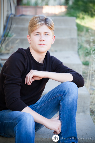 CA Senior Gabriel sits on steps during senior portrait session 