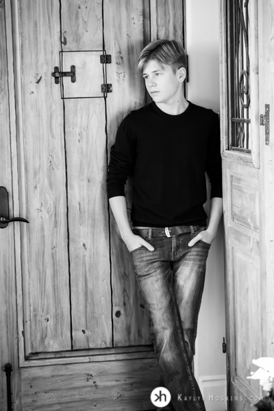 California Senior Gabe leaning on wooden door during his senior portraits with Kaylyn Hoskins Photography