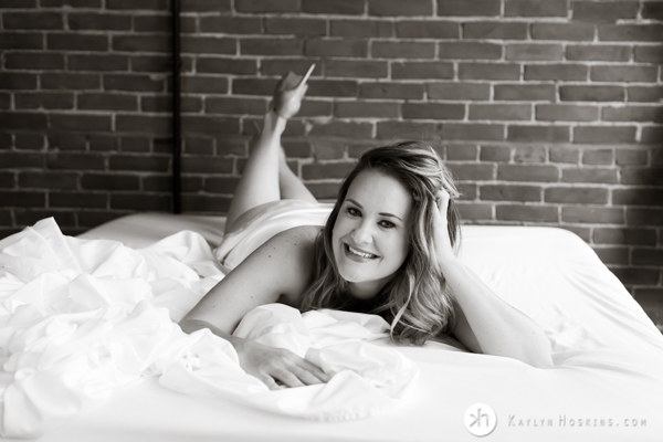 sexy basketball coach lays on bed during boudoir photo shoot in solon iowa