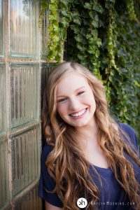 Gorgeous Gracen smiling big while leaning up against old glass block window downtown iowa city