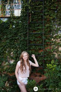 Solon Senior holding on ladder rung during senior photos downtown Iowa City