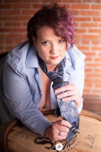 Curvy Girl leaning on whiskey barrel in man's shirt and tie