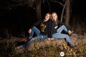 Solon Senior and her big sister pose on log at lake macbride during fall senior session