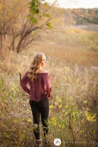 Iowa Senior girl standing by lake macbride during fall senior photos 