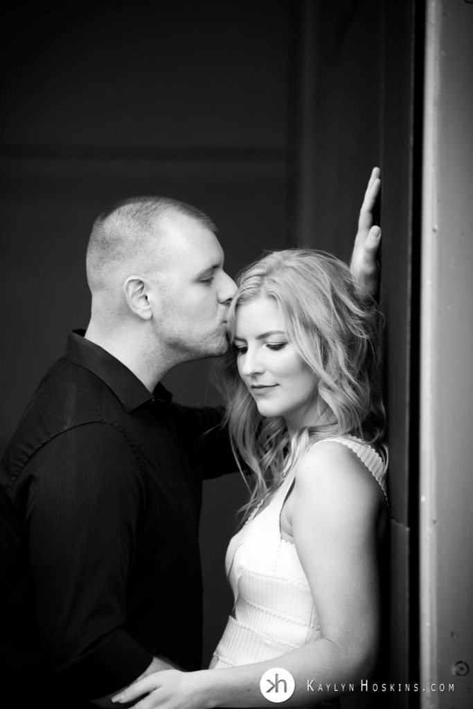 Man kisses fiance's forehead during engagement photo shoot downtown iowa city