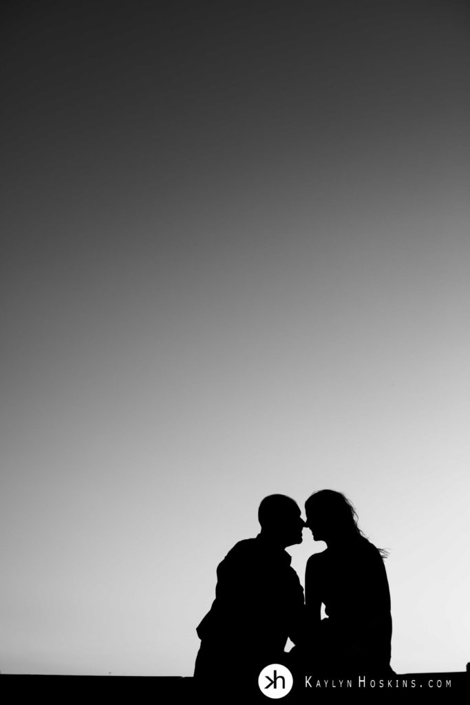 Engagement couple silhouetted at sunset at Old Capital in Iowa City