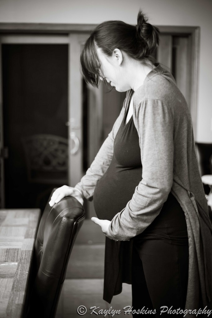 Home birthing Mother holds onto chair during strong contraction