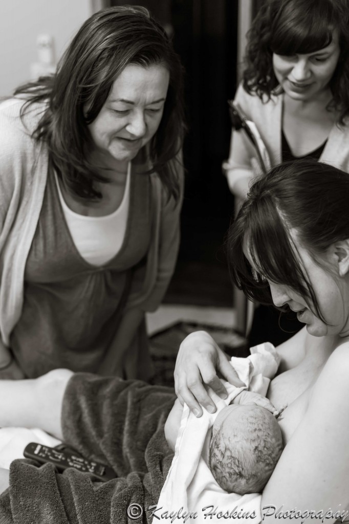 Midwives adore home water birthed baby boy with Mother holding him