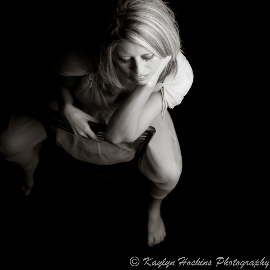 Beautiful woman leans on vintage chair in vintage lingerie during boudoir experience