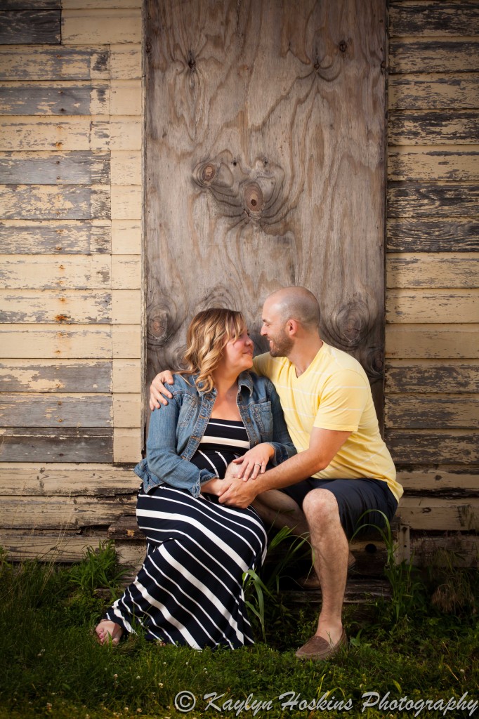 engagement couple sit on steps of old building while adoring each other