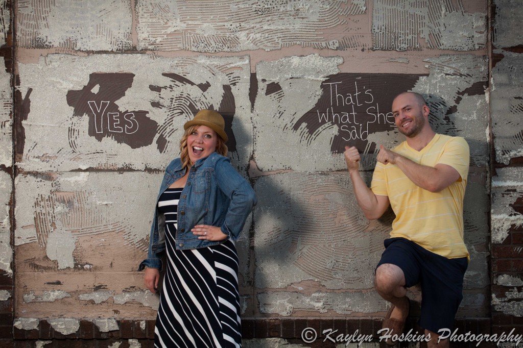 Engagement couple lean against wall after they wrote YES 'THAT'S WHAT SHE SAID' in Czech Village