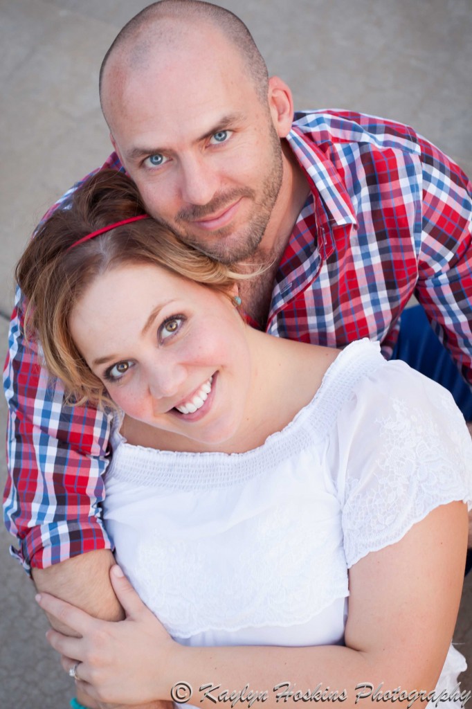 fiance wraps arms around his bride to be during engagement photo session