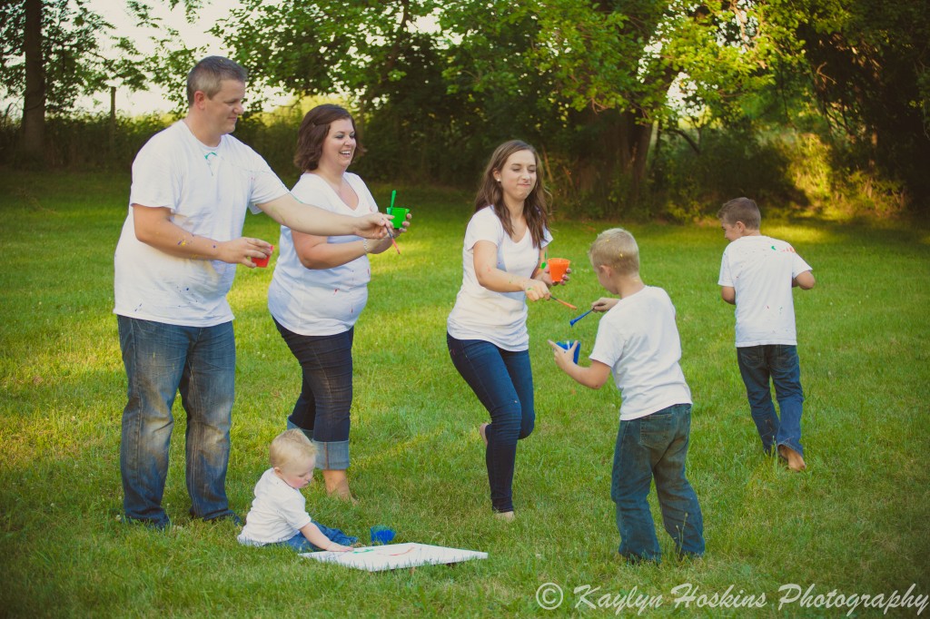 Family of 6 begin the paint fight fun during family pictures with Kaylyn Hoskins Photography