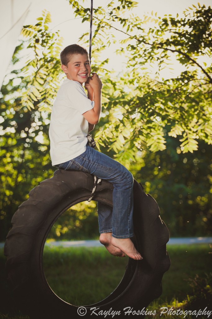 Son plays on tire swing during family pictures