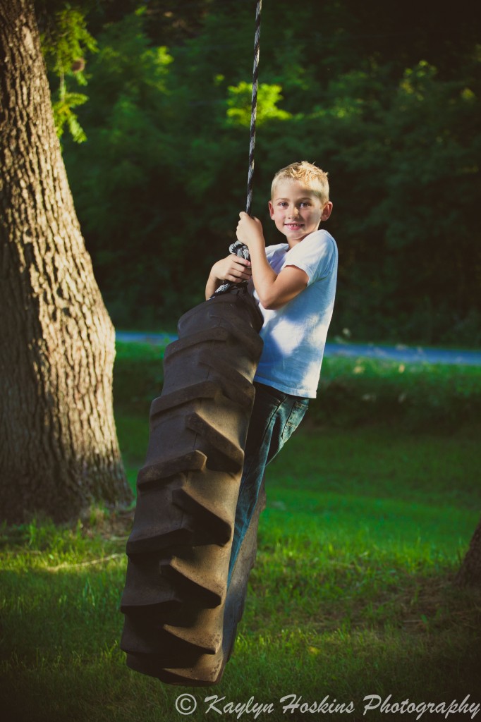 Son plays on tire swing during family pictures with Kaylyn Hoskins Photography