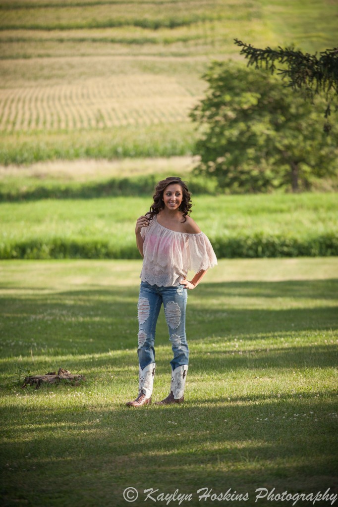 Solon Senior stands in field during her senior session with Kaylyn Hoskins Photography