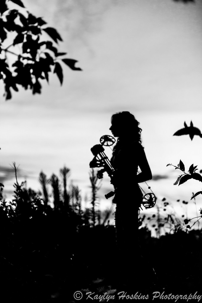 Beautiful HS Senior silhouetted with bow during Senior Pics at Harvest Preserve in Iowa City, IA