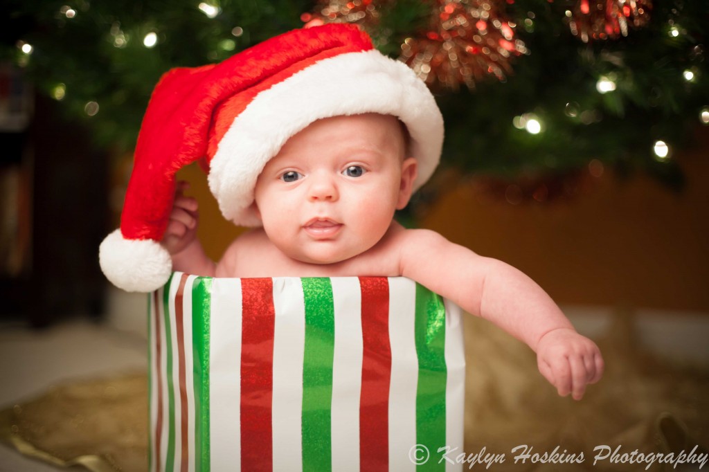 new baby in gift box under christmas tree with santa hat