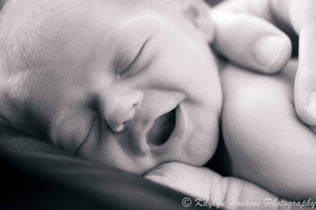 newborn sonny smiling in his sleep while laying on his dad's chest