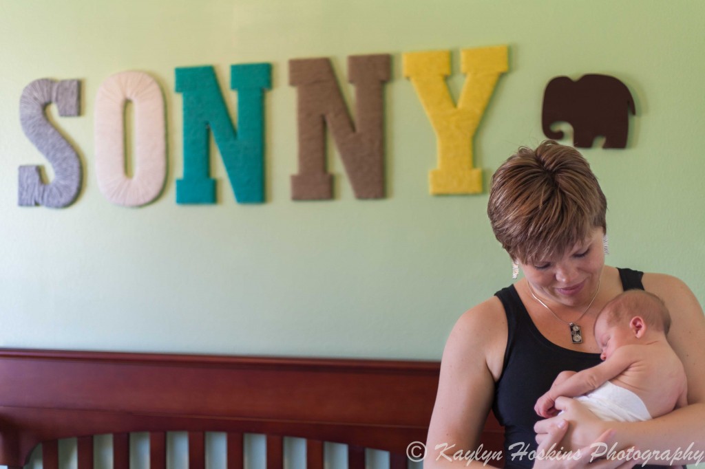 newborn in mom's arms in nursery