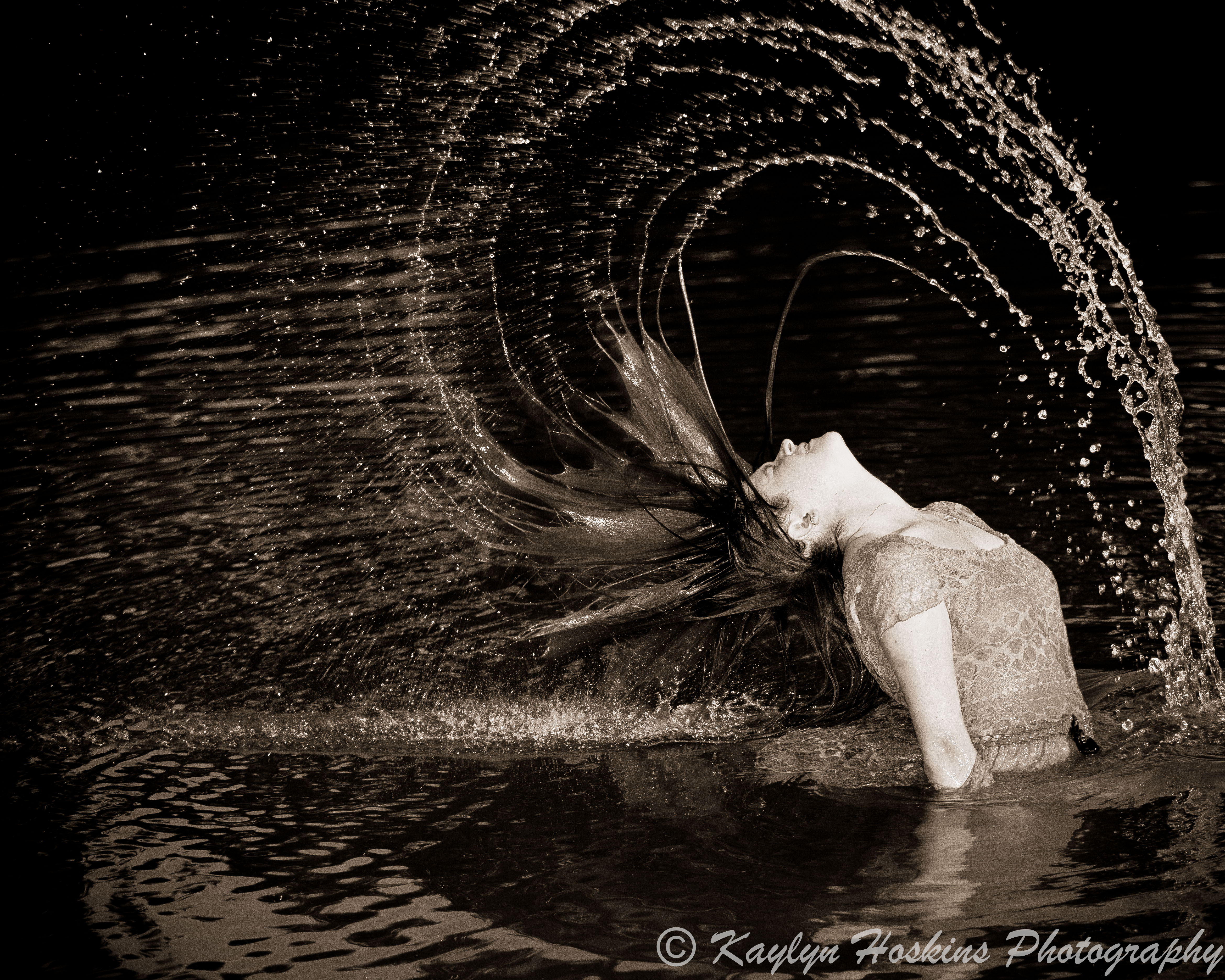 girl flips hair in water during senior photos at Harvest Preserve in Iowa City