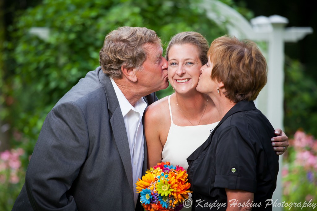 Beautiful Bride gets kisses from her Mom and Dad before walking down the isle at Little Brown Church in Nashua, IA