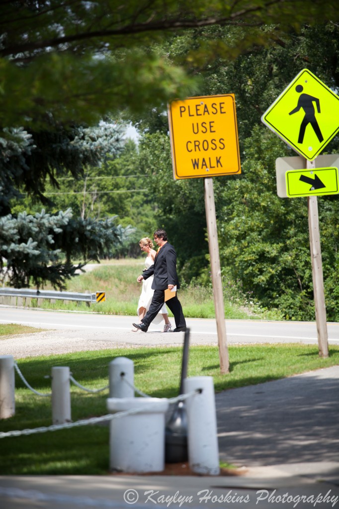 Bride and groom walk across the road to get to the Little Brown Church before their wedding.