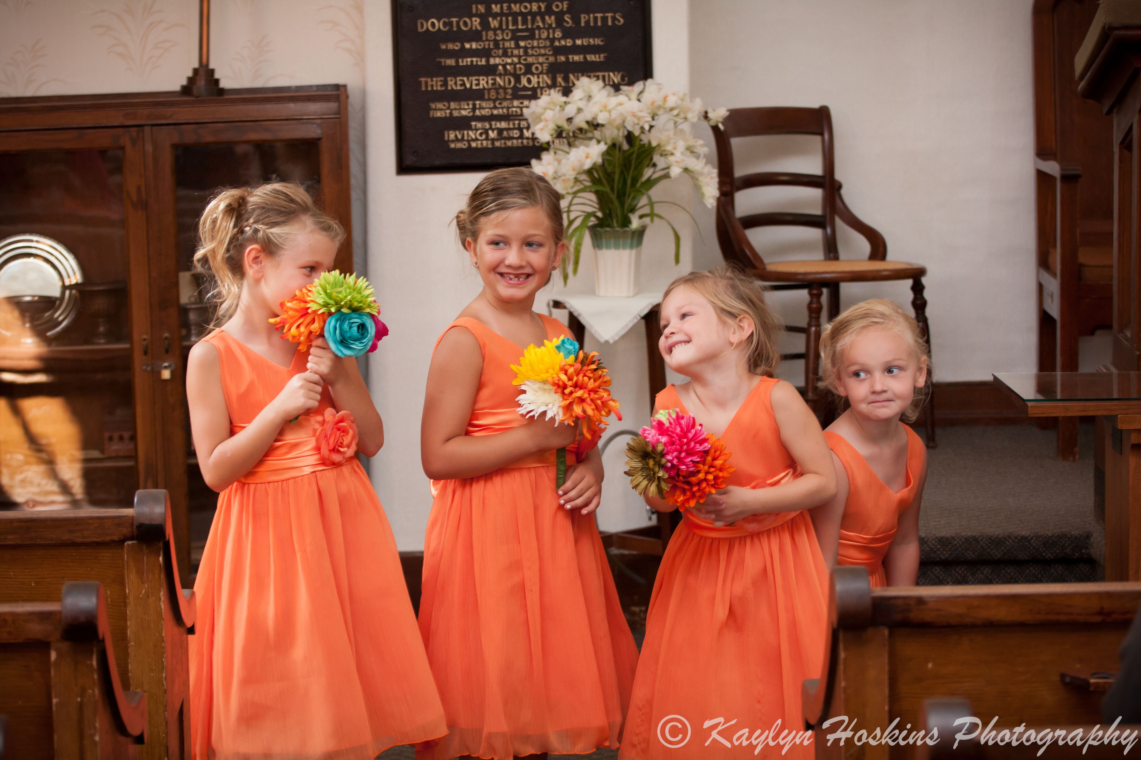 The young bridesmaids having fun during wedding ceremony at the Little Brown Church in Nashua, IA