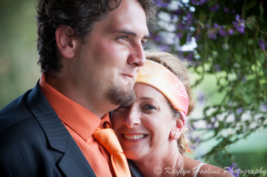 Gorgeous bride smiles as she leans on grooms shoulder