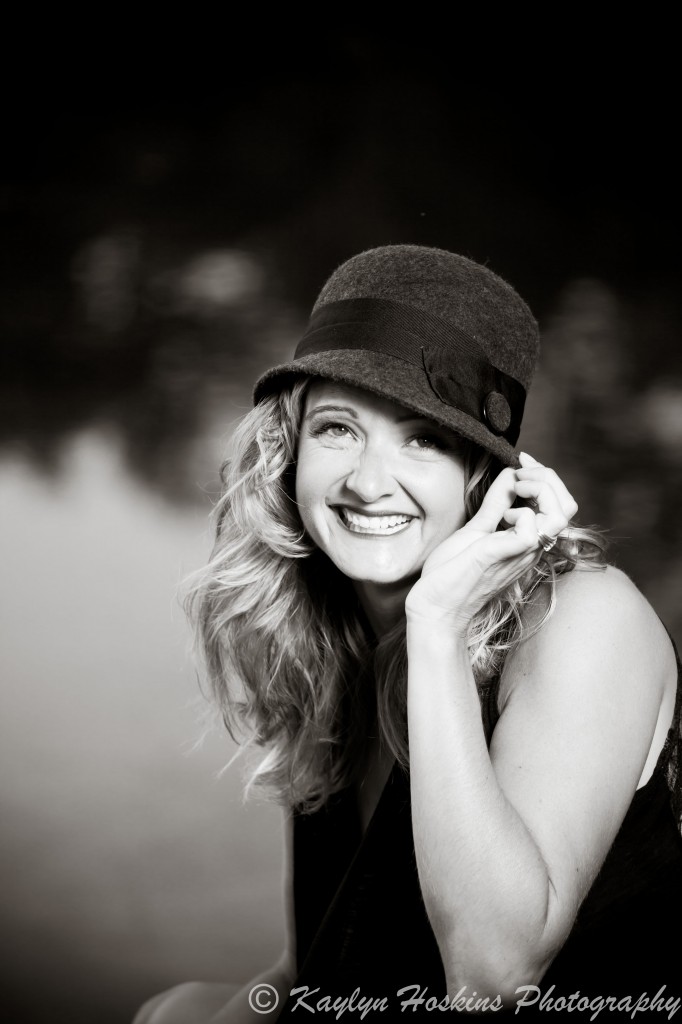 Beautiful woman smiling while she plays with her hat.