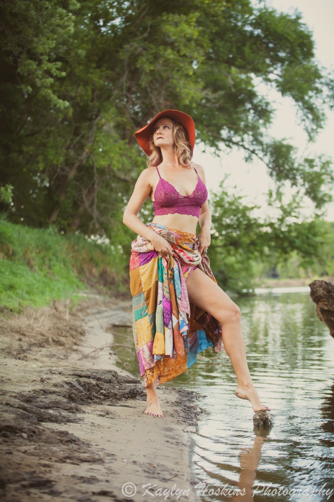 Gorgeous woman standing in river showing some leg